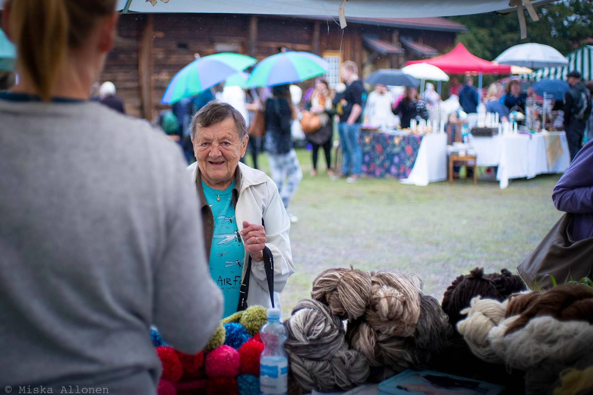 Vanhempi nainen ostaa lankoja Voipaalan markkinoilla