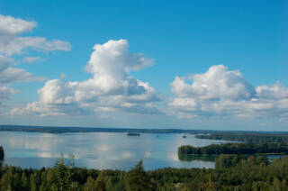 Näkymä Rapolanharjulta järvelle, taivaalla muutama poutapilvi.